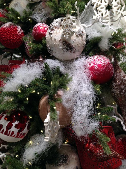 A Christmas tree adorned with red, white, and silver ornaments, white mesh, warm lights, and a festive dusting from the Bag of Faux Snow for a magical holiday look.