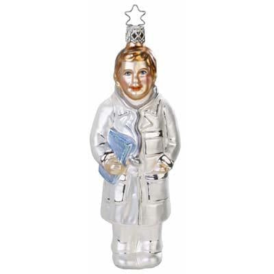 The Inge-Glas of Germany 1-111-12 Doc Holiday Christmas Ornament features mouth blown glass shaped like a person in a silver coat, holding a blue book, with gold hair and a star-shaped hanging loop.