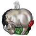 The Eeyore Old World Christmas 12704 ornament is a shiny silver donkey with a black mane and tail, adorned with a red saddle and glittery accents. It stands on a green base as a symbol of endurance and includes a silver cap for easy hanging.