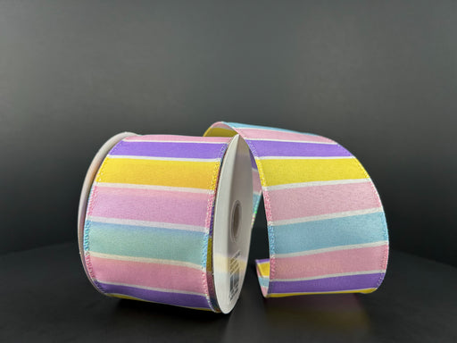 Two spools of the 2.5"X10Y Lavender-Yellow-Pink-Lt Blue-White Wide Stripes Ribbon 31402-40-02 are set against a dark backdrop, showcasing their wide pastel stripes in alternating shades of pink, yellow, lavender, light blue, and green.
