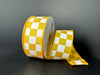 A spool of 1.5X10Y Yellow Satin/White Racechex Ribbon 41531-09-49 is placed on a black background, with one end unfurled to highlight its checkered design.