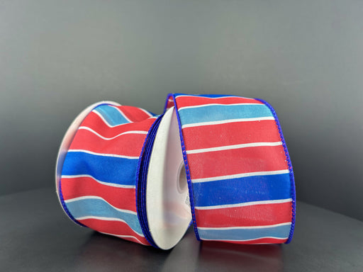 Two rolls of the 2.5X10Y Red-Royal Blue-Lt Blue-White Wide Stripes Ribbon 42403-40-25 are displayed against a plain gray background, slightly tilted to showcase their vibrant colors and glossy texture.