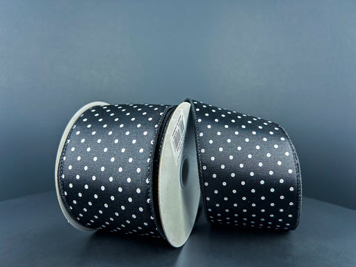 Two rolls of 2.5X10Y Black Ribbed Satin/White Microdots Ribbon 42419-40-21 are set against a gray background, angled slightly towards each other, exuding a shiny, textured elegance.
