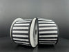 Two spools of 2.5X10Y Black Satin-White Stripes/Black Edge Ribbon 46425-40-21 stand upright against a dark background, leaning against each other and showcasing the bold horizontal stripe pattern beautifully.