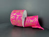 A partially unrolled 2.5x10y fuchsia satin ribbon with a black skull paisley pattern (51513-40-28) is displayed against a plain dark background.
