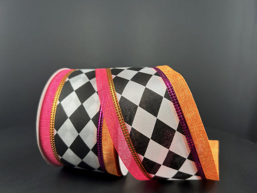 A spool of 2.5X10Y Black and White Harlequin Satin/Orange-Hot Pink Linen Edge Ribbon 56426-40-19 is unrolled, displaying its diamond pattern and vibrant edges against a dark background.
