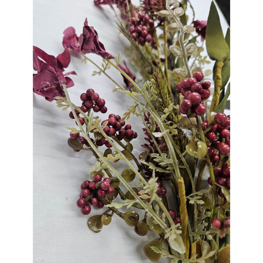 A close-up of the 24 Burgundy Lavender Berry Spray 63048-BG, showcasing clusters of small burgundy berries and green leaves on pale stems against a plain white background.