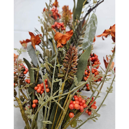 A close-up of the 24 Orange Lavender Berry Spray 63048-OR highlights artificial green leaves, orange lavender berries, brown pinecones, and orange flowers beautifully arranged against a light background.