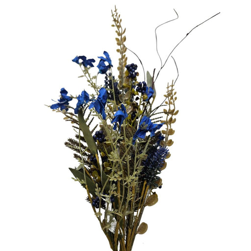 The 24 Royal Blue Lavender Berry Spray (63048-RO BL) features vivid royal blue flowers with vibrant green and brown leaves, arranged in a natural, wild style. It stands elegantly against a plain, white backdrop.