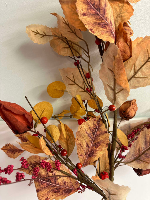 A close-up of the 32 In Mixed Berries, Leaves, and Lantern 64426 shows brown, orange, and yellow leaves with mixed berries on thin branches against a light background.
