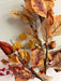 A close-up of the 32 In Mixed Berries, Leaves, and Lantern 64426 shows brown, orange, and yellow leaves with mixed berries on thin branches against a light background.