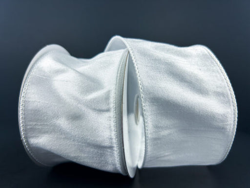 Two rolls of 2.5X10Y White Faux Dupioni Ribbon 72434-40-01, with a shiny, slightly crinkled texture, are set against a dark background, highlighting their reflective quality.