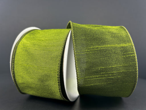 A close-up of the 2.5X10Y Moss Green Faux Dupioni Ribbon 72434-40-08 shows its wide, shiny, wired edges partially unspooled against a plain dark background.