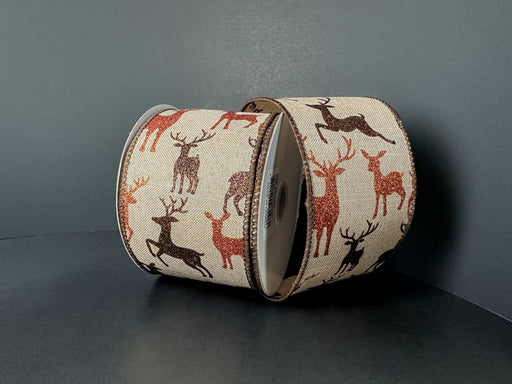 Two rolls of 2.5X10Y Natural Linen/Brown-Rust Glitter Deer Ribbon (73552-40-31) with repeating deer silhouettes in brown, black, and red on natural linen, set against a dark background.