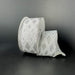 A spool of 1.5X10Y White-Silver Linen/Silver Metallic Diamond Cascade Ribbon (73559-09-16) with a geometric silver diamond pattern is unwound on a dark, plain surface and background.