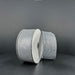 Two spools of 1.5X10Y Silver Stairstep Woven Metallic Ribbon (76310-09-51) sit side by side on a dark, matte surface against a neutral background.