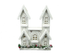 The 12 White House with 10 LED Lights (84014WT) is a decorative white wooden house with three snowy peaked roofs and a base adorned with pinecones, greenery, and red ornaments, all set on a plain gray background.