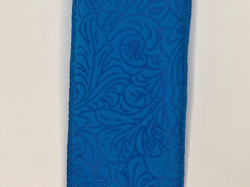 Close-up of the 2.5X10Y Turquoise Flower Embossed Ribbon (984240-39) features intricate turquoise leather with embossed floral patterns, including swirls and leaf-like shapes, adding texture and elegance.