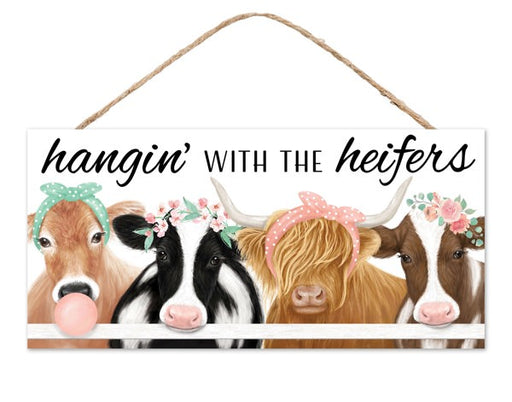 Illustration of four cows in bandanas and flowers behind a fence with a playful Hangin with the Heifers text. This 12.5 L Mint/Cream/Light Brown Mdf Sign AP7350 adds warmth and whimsy to any space.