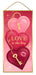 The 12.5 H x 6 Pink/Burgundy/Gold/White MDF Love Is The Key Sign (AP7360) features three stacked heart shapes with gold keyholes, a gold key, LOVE is the key on the center heart, and a lipstick kiss on the bottom heart.