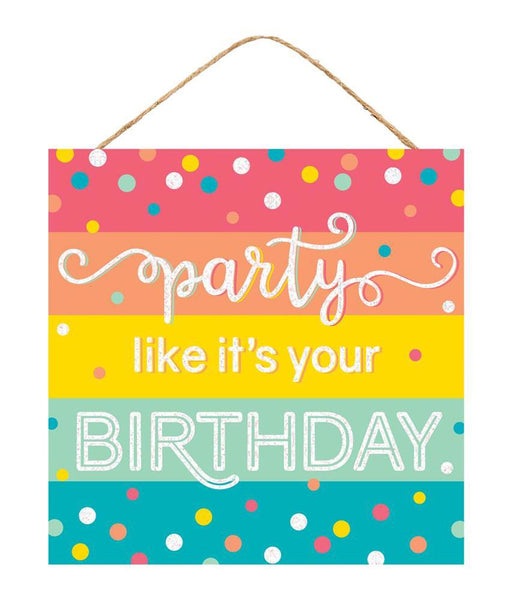 The 10Sq Glitter Party/Birthday Sign Pastel Multi AP783061 features vivid stripes in pink, orange, yellow, green, and blue with Party like its your BIRTHDAY in white. The backdrop is dotted with multicolored polka dots for lively pastel décor and hangs by a rope.