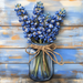 A bouquet of blue flowers in a clear jar tied with twine contrasts beautifully with rustic wood, ideal for home decor. The combination mirrors the charm of a 10 x 10 Bluebonnet Bundle Sign TTE-172.