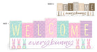The 21L Pastel Natural Double-Sided Welcome Every Bunny sign (HE7386) features colorful blocks and bunny silhouettes on one side, and small bunny graphics with the same greeting on a neutral background on the other.