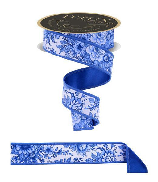 A spool of DLUXE 1.5 x 10YD White and Multi Blue Chinoiserie Floral Fused Ribbon (LX312203) features a blue and white pattern with blue edging, partly unrolled in a loose curve for display. Crafted for durability.