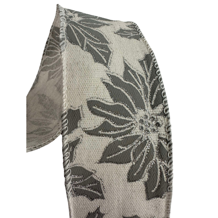 A close-up of the 2.5" Gray Burlap with Gray Poinsettia Wired Ribbon R32934 showcases a pattern of dark gray and light gray flowers with embroidered edges. The wired ribbon is slightly curved against a plain white background, adding subtle elegance with its floral design in shades of gray and silver.