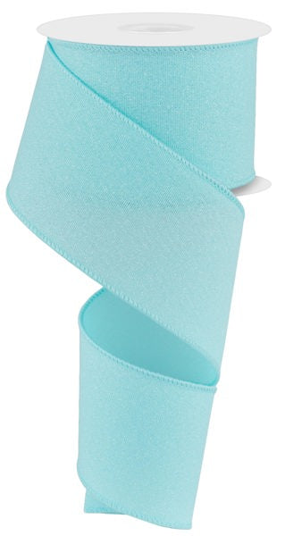 The 2.5X10YD Ice Blue Crystal Shine Ribbon RGE1995H1 cascades elegantly from its spool, partially unspooled with a smooth, spiraling appearance against a plain white background.