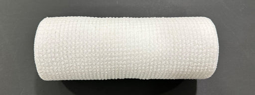 A close-up of the 10X10Y White All Snow Fuzz Mesh XB253610-01 medical bandage roll, showcasing its textured surface against a black background.