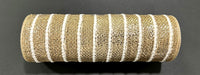 A 10X10Y Champagne Heavy Metallic Snowball Mesh ribbon (XB254610-14) with white stripes lies on a dark surface, its metallic woven texture and cylindrical shape reflecting the light.