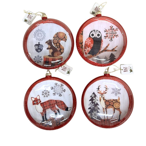 Set of four assorted RAZ Exclusive glass disc ornaments (SKU 3523101) featuring woodland animals — an owl, deer, squirrel, and fox. Each ornament has a red glittered trim and back, measures 6 inches, and showcases artwork by Jennifer Brinley. Available at Trendy Tree.