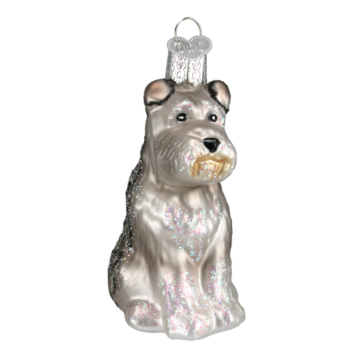 The Schnauzer Dog 12264 Old World Christmas Ornament Assorted is a glass-crafted piece featuring a sitting pup with silver and glittery details. Hand-painted for charm, it includes an ornate cap for easy hanging.