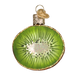 The Kiwi Ornament Old World Christmas Ornament 28115 features a circular design resembling a sliced kiwi with realistic green flesh, black seeds, gold glitter edges, and is topped with a golden cap and loop for hanging. It also includes a textured blue charm.