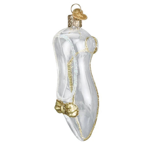 The Cinderellas Slipper Old World Christmas Ornament 32004 is a glass ornament shaped like a glass slipper, adorned with gold and white glitter accents, and finished with a gold bow near the toe.