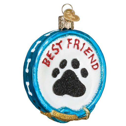 The Dog Collar 36216 Old World Christmas Ornament is a round, blue hand-painted glass ornament featuring white bone accents, BEST FRIEND in red above a black glittery paw print, resembling a festive dog collar.