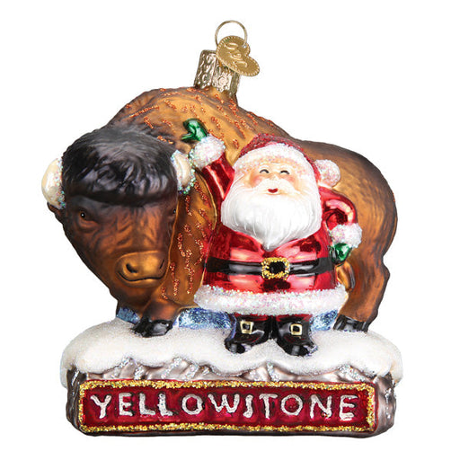 This Santa With Bison Ornament from Old World Christmas (Product Code: 40305) features a joyful Santa in his classic red suit next to a majestic bison, all set on a snowy Yellowstone base and capturing the essence of holiday cheer with Santa's cheerful wave.