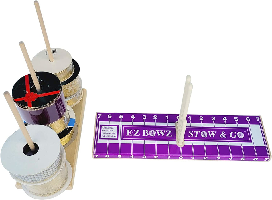 The EZ Bowz Stow & Go Bow Maker is a crafting tool set with vibrant ribbon spools on a wooden stand. It features measurement markings and pegs for arranging ribbons, ideal for those who value organization and versatility in their projects.