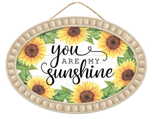 The 13Lx9H You Are My Sunshine sign (AP7207) features a beaded edge with vibrant sunflowers and elegant script on a white wood background, perfect for adding charm to your home decor. Available in Yellow/Brown/Green/Tan/White/Black.