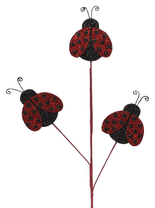 The 25 Glitter Lady Bug Pick features three stylized ladybug decorations with red and black dotted wings on slender stems. Curled antennae add a decorative touch against a white background. Product Code: MN0043.