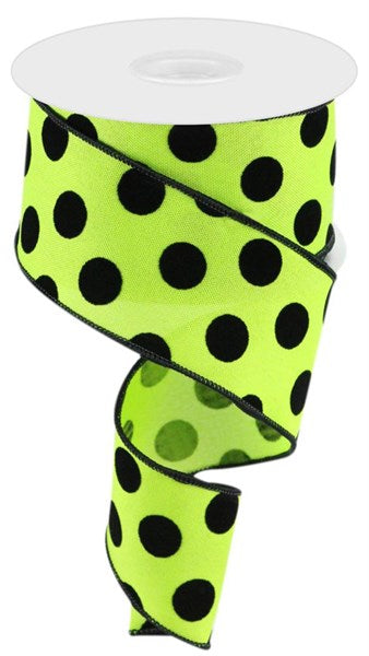 A partially unwound roll of 2.5 X 10 yards lime green/black velvet polka dot ribbon, model RGC162933, reveals its vibrant pattern.