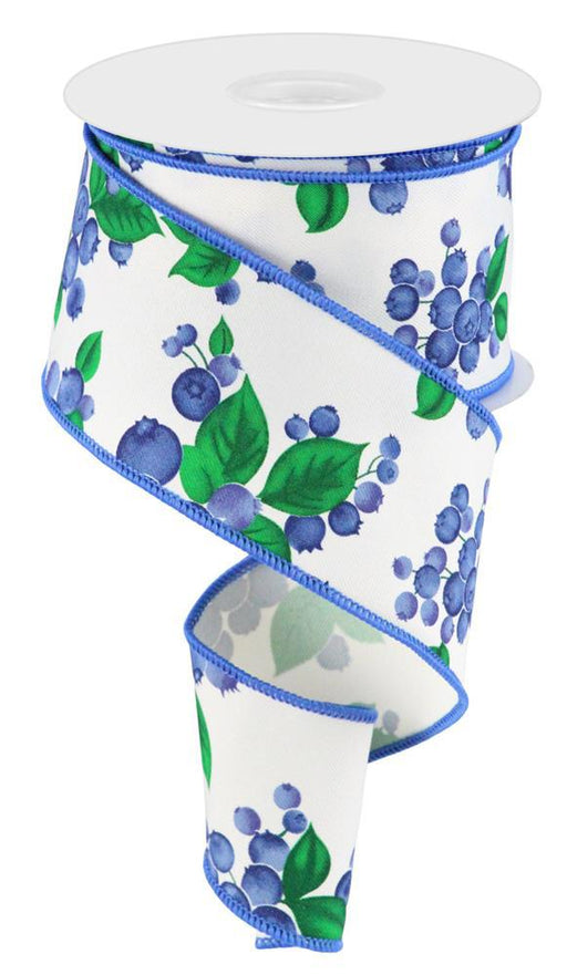 The 2.5X10Yd Blueberries Ivory/Blue/Green RGC175333 wired ribbon is elegantly coiled on display, showcasing clusters of blueberries and green leaves on a white background with blue edging—ideal for adding nature-inspired elegance to any project.