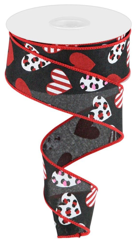 This elegant 1.5" x 10-yard roll of multi/leopard hearts ribbon in Black/Red/Hot Pink/White (RGC177602) features a black background with red edges, adorned with charming heart designs in red, white, polka dots, and stripes. When partially unfurled in a spiral shape, it brings chic flair to any craft project.