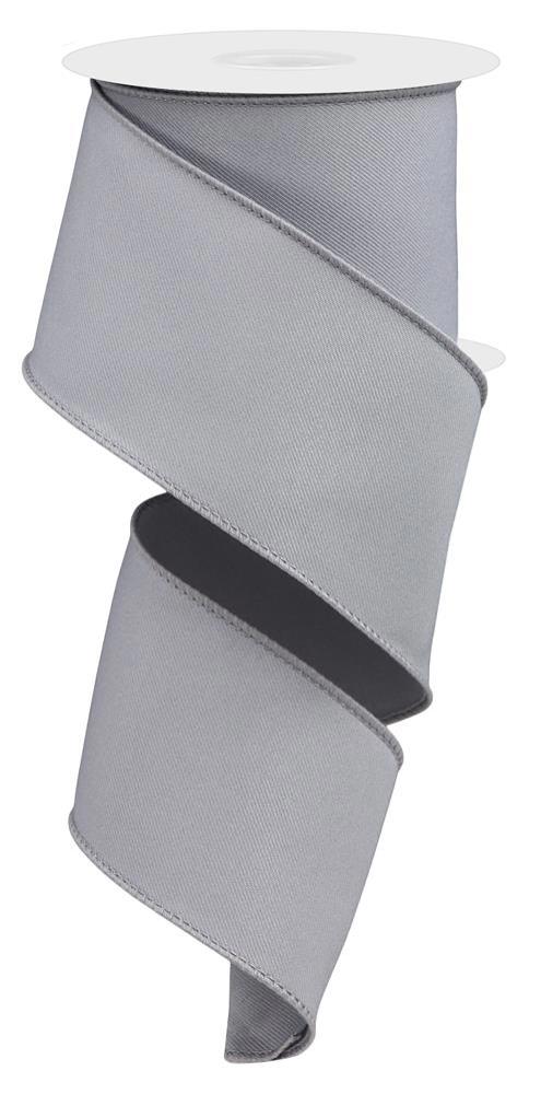 The 2.5X10Yd Diagonal Weave Fabric Grey RGE120310 unwinds elegantly in a spiral, with the grey ribbon cascading from the top of the white spool.
