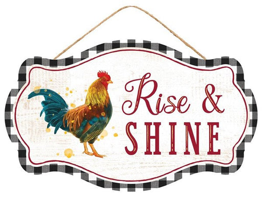 Labeled AP7083, this 12.5x7.5 sign features a checkered black and white border, a colorful rooster on the left, and Rise & Shine in bold red on a white background. It hangs elegantly by a thin rope.