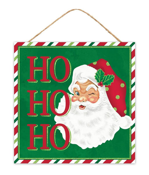 This delightful 10" square "Ho Ho Ho" Santa Sign (AP8920), crafted from MDF, showcases a merry image of Santa Claus winking under his holly-adorned red hat. The emerald green background accentuates the jolly "HO HO HO" in red and white text, framed by festive stripes of red, green, and lime.