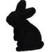 The HE723899 product is a 4Hx2.5L flocked standing rabbit in furry black, facing left with upright ears and a seated posture. Its silhouette stands out elegantly against a smooth polystyrene-like background on a white backdrop.