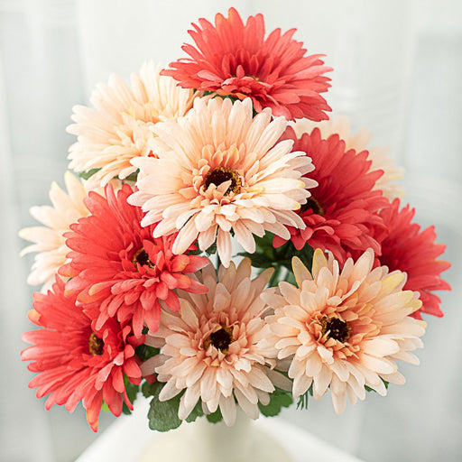 A bouquet of 18 coral gerbera daisies with 12 stems in a vase, set against a soft, light background.