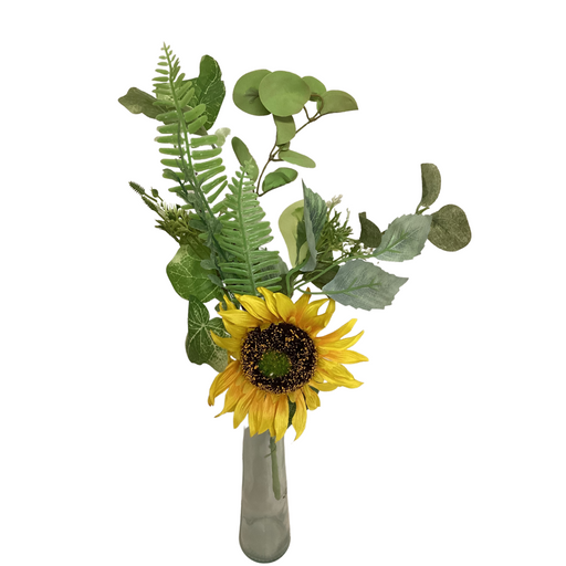 The 19 Yellow Sunflower Pick 62202 features a vibrant yellow sunflower with a dark center, arranged in a simple vase alongside green eucalyptus and fern leaves. The white background enhances the lively and fresh display of colors.